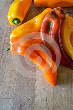 Group of sweet organic pointed peppers on a wooden cutting board