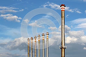 Group of tall chimney from steel factory under sky