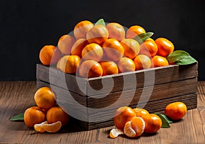 Group of tangerines with green leaves in a wooden box