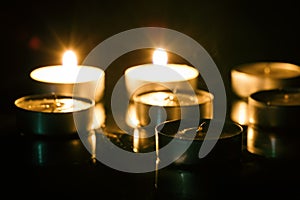 Group of tea candles on a black background. Selective focus