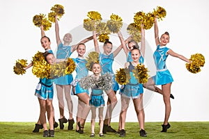 The group of teen cheerleaders posing at white studio