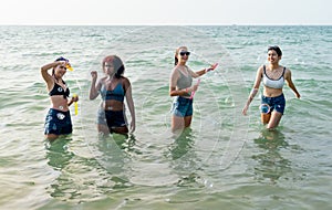 Group of teen girl enjoy and fun with soapsuds or soap bubbles during play together in the sea on holiday or vacation
