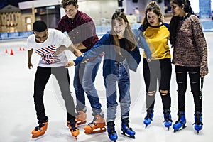 Group of teenage friends ice skating on an ice rink