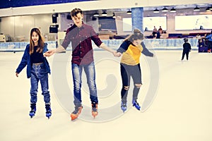 Group of teenage friends ice skating on an ice rink