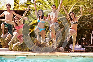 Group Of Teenage Friends Jumping Into Swimming Pool