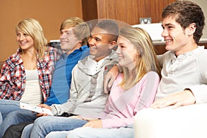 Group Of Teenage Friends Sitting On Sofa At Home