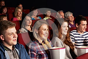 Group Of Teenage Friends Watching Film In Cinema