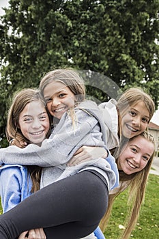 Group of teenage girls playing and smiling together outdoors