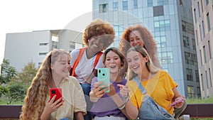 Group of teenage girls using a mobilephone. Young women watching their smart phones. Female friends sharing on the