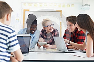 Group Of Teenage Students Collaborating On Project In IT Class