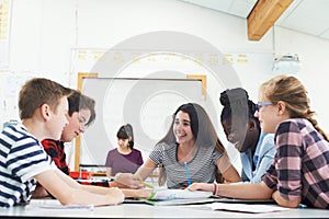 Group Of Teenage Students Collaborating On Project In Classroom photo