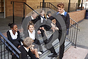 Group Of Teenage Students In Uniform Outside School Building