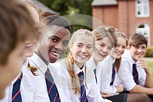 Group Of Teenage Students In Uniform Outside School Buildings