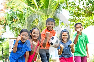 group of teenager kids with football shouting by looking at camera - conecept of excitement, entertainment and