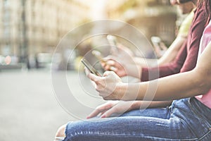 Group of teenagers friends watching mobile phones in city - Young people addiction to technology trends - Alienation moment for