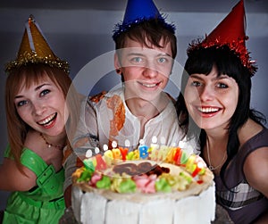 Group of teenagers with happy birthday cake.