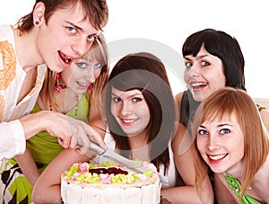 Group of teenagers with happy birthday cake.