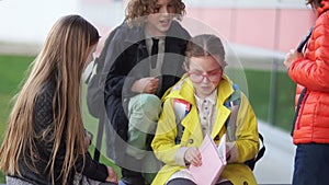 A group of teenagers humiliate a defenseless girl with glasses. Adolescent violence, problems, physical abuse at school