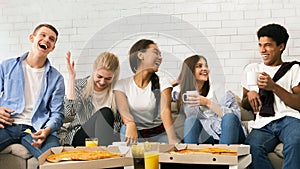 Group of Teenagers Laughing and Eating Pizza on a Couch