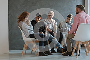 A group of teenagers looking at a withdrawn, lacking self-esteem girl