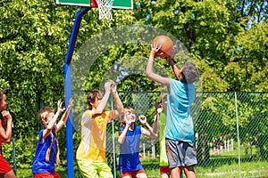 Group of teenagers play basketball on playground