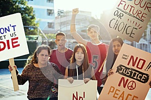 Group of teenagers protesting demonstration holding posters antiwar justice peace concept photo