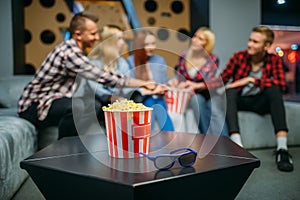 Group of teenagers relax on couch in cinema hall
