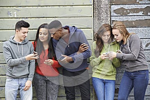 Grupo de adolescentes intercambio un mensaje sobre el móvil telefonos 