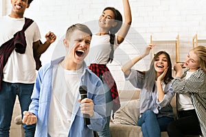 Group of Teenagers Singing Into a Microphone