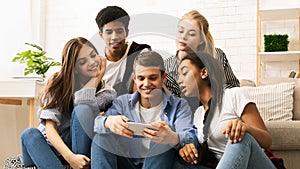 Group of Teenagers Sitting on Couch Looking at Cell Phone