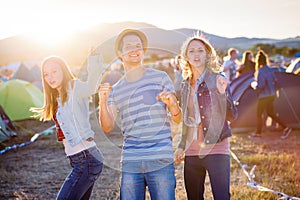 Group of teenagers at summer music festival, sunny day