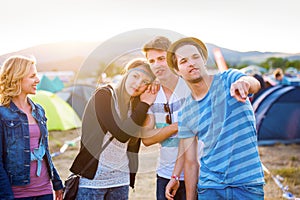 Group of teenagers at summer music festival, sunny day