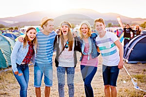 Group of teenagers at summer music festival, sunny day