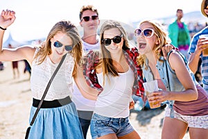 Group of teenagers at summer music festival, sunny day