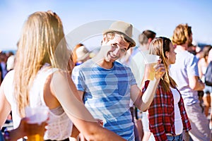 Group of teenagers at summer music festival, sunny day