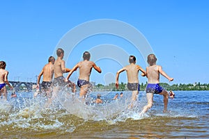 Group of teens run into water