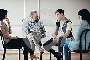 Group therapy with psychologist and depressed man and woman