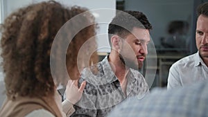 group therapy, young man talks about his experiences to people during psychological training sitting in circle