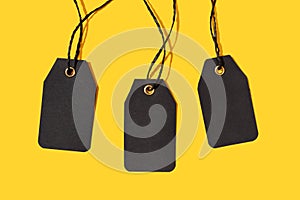 Group of three Blank black tags isolated on yellow background