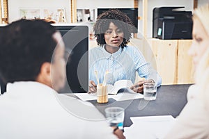 Group of three coworkers make great discussing about business plans in modern office. Young people working together. Horizontal