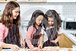 Group of three Diverse Family, Asian and Arab Preschool kid person make Cake cooking in kitchen,