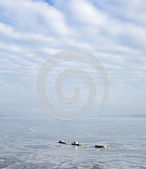 Group of three fishing boats in ice captive in cold winter day