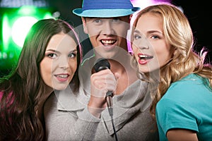 Group of three friends singing with microphone.