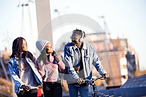 Group of three friends walking and laughing in the street.