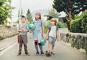 Group of three funny kids wearing backpacks walking back to school