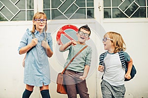 Group of three funny kids wearing backpacks walking back to school