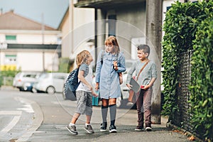 Group of three funny kids wearing backpacks walking back to school