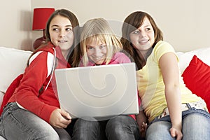 Group Of Three Girls Using Laptop At Home