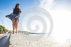 Group of three girls walking on a wall near the beach