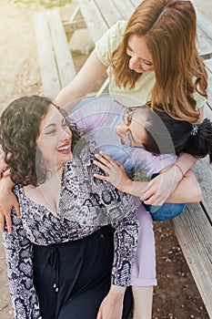 Group of three happy girlfriends embracing and smiling. Females enjoy friendship. Sorority women